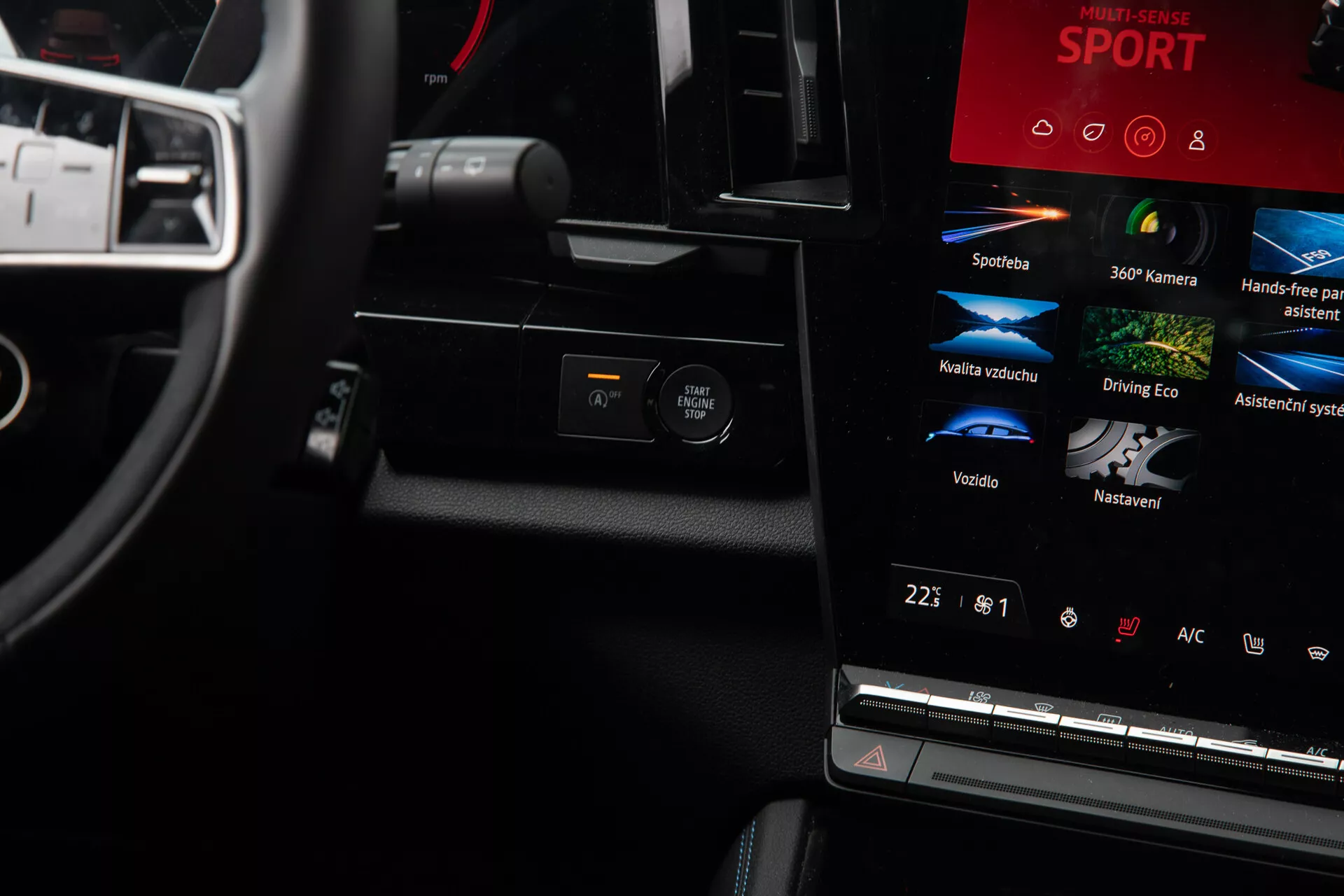 Podroben pogled na notranjost Renault Austral 2022, osredotočen na armaturno ploščo in sredinsko konzolo z zaslonom na dotik za infotainment, večfunkcijskim volanom, oblečenim v usnje, in nastavitvami za klimatsko napravo