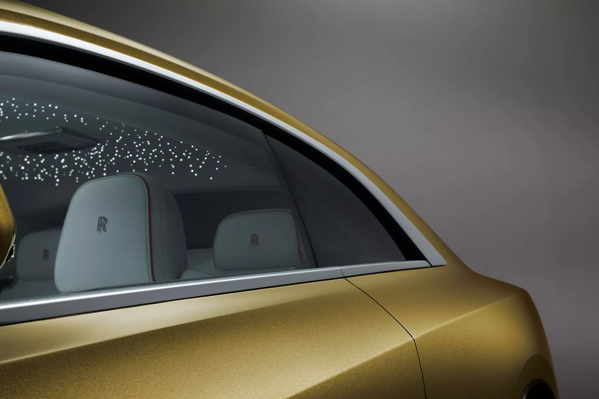 Podroben stranski pogled na Rolls-Royce Spectre 2023, prikazuje metalik zlato barvo, dizajn zadnjega okna, elegantno tehnologijo vrat in luksuzne blagovne znamke