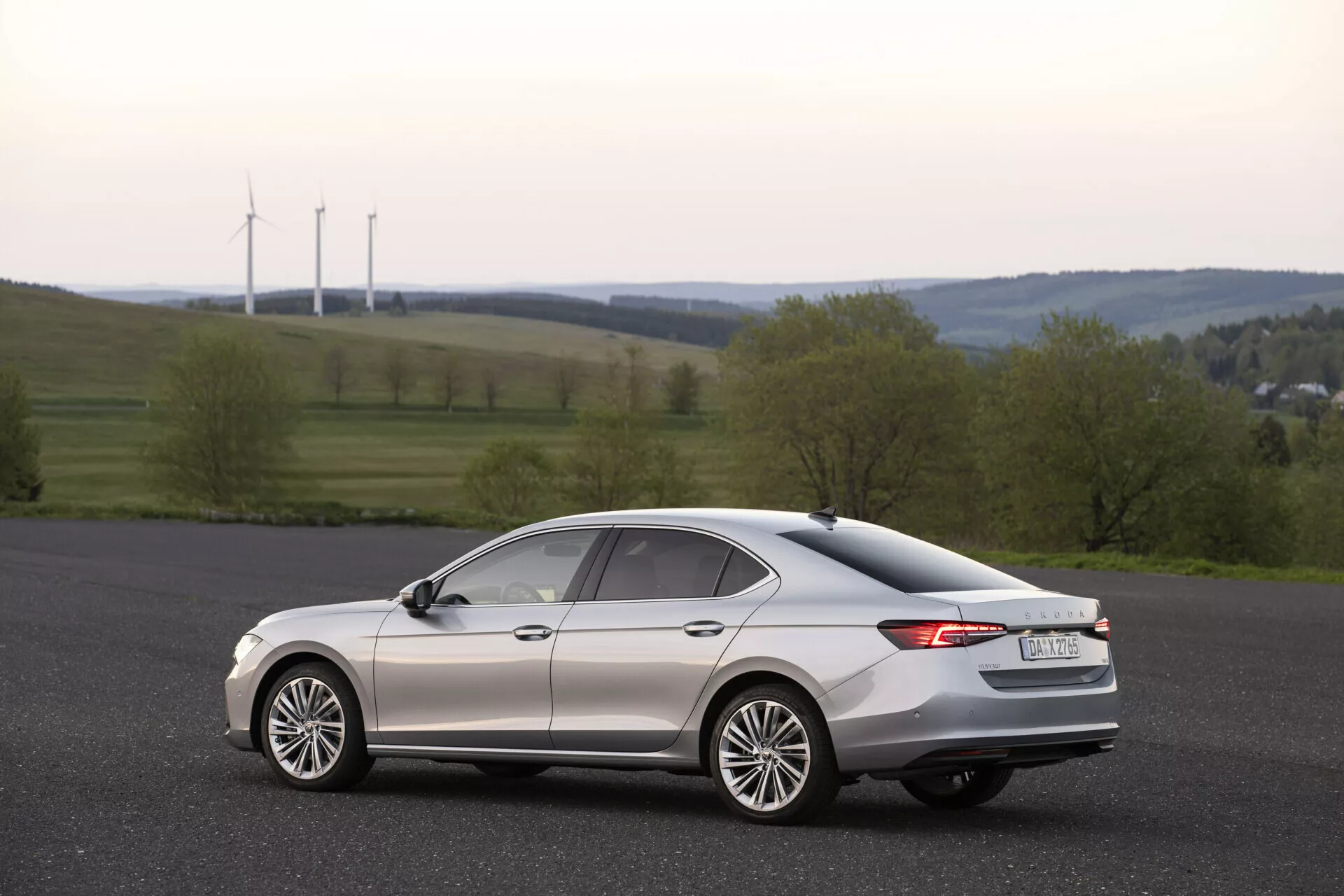 Skoda Superb Limousine 2024 - spredaj poudarja eleganten, aerodinamičen dizajn z vrhunskimi LED žarometi, kromirano masko in kovinskim končanjem, ki prikazuje razkošno eleganco.