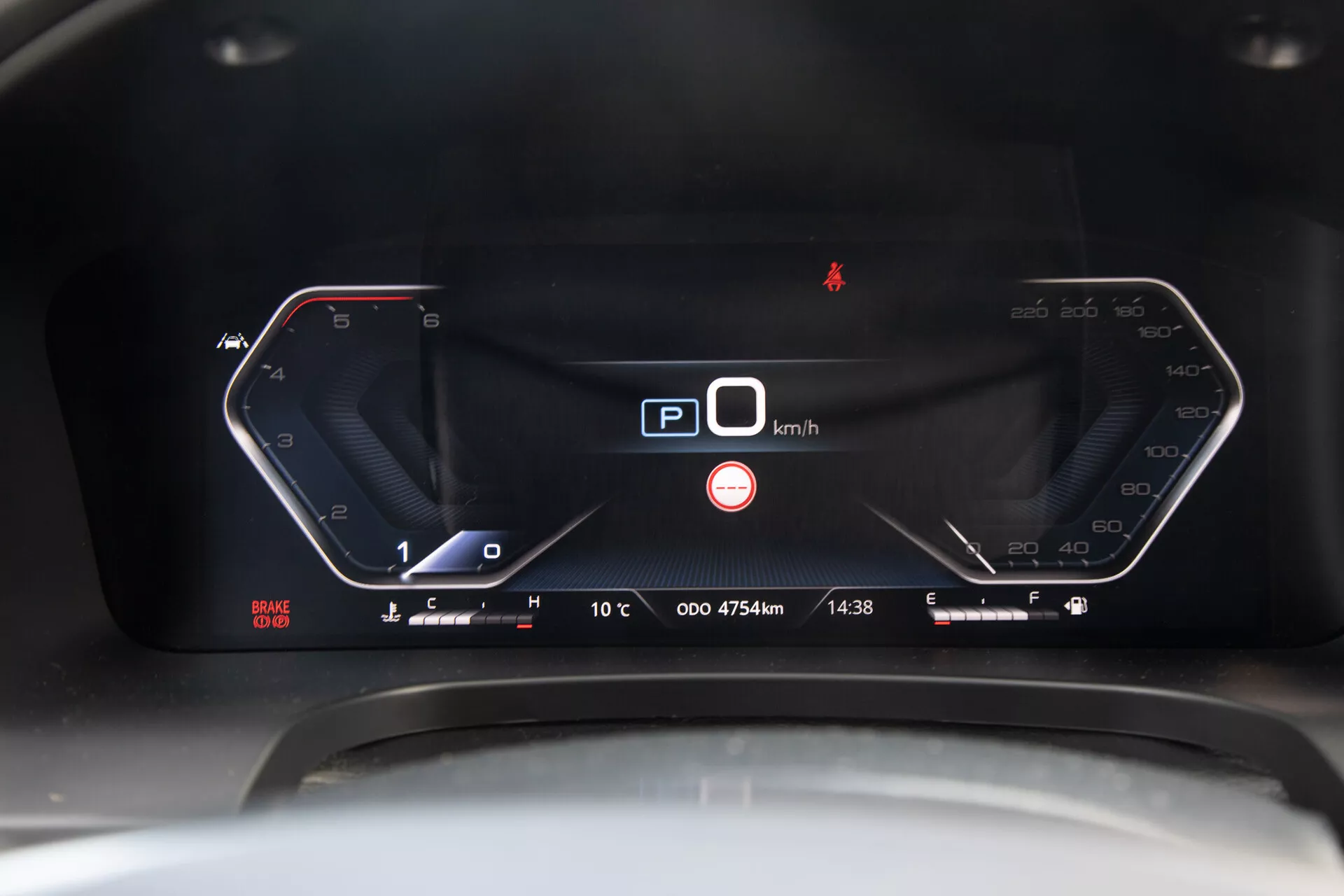 Podrobni posnetek digitalne armaturne plošče pickupa SsangYong Musso Grande 2022, ki prikazuje hitrostomer pri 0 km/h, indikator parkirne prestave in napredne tehnološke lastnosti