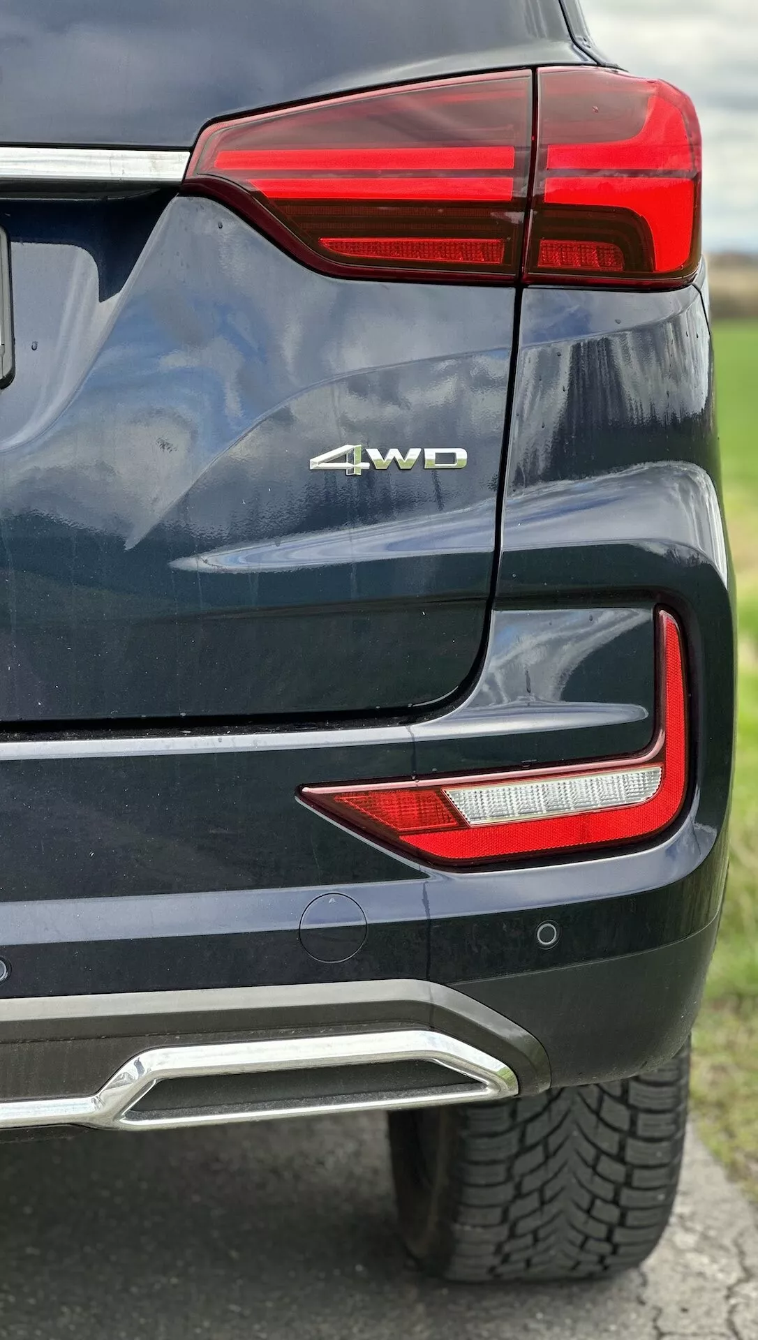 Podrobni pogled na zadnji kot SsangYong Rexton 2021, ki prikazuje LED zadnjo svetlobno skupino, značko 4WD, senzor za parkiranje, integrirano pokrivalo izpuha v metalni barvi
