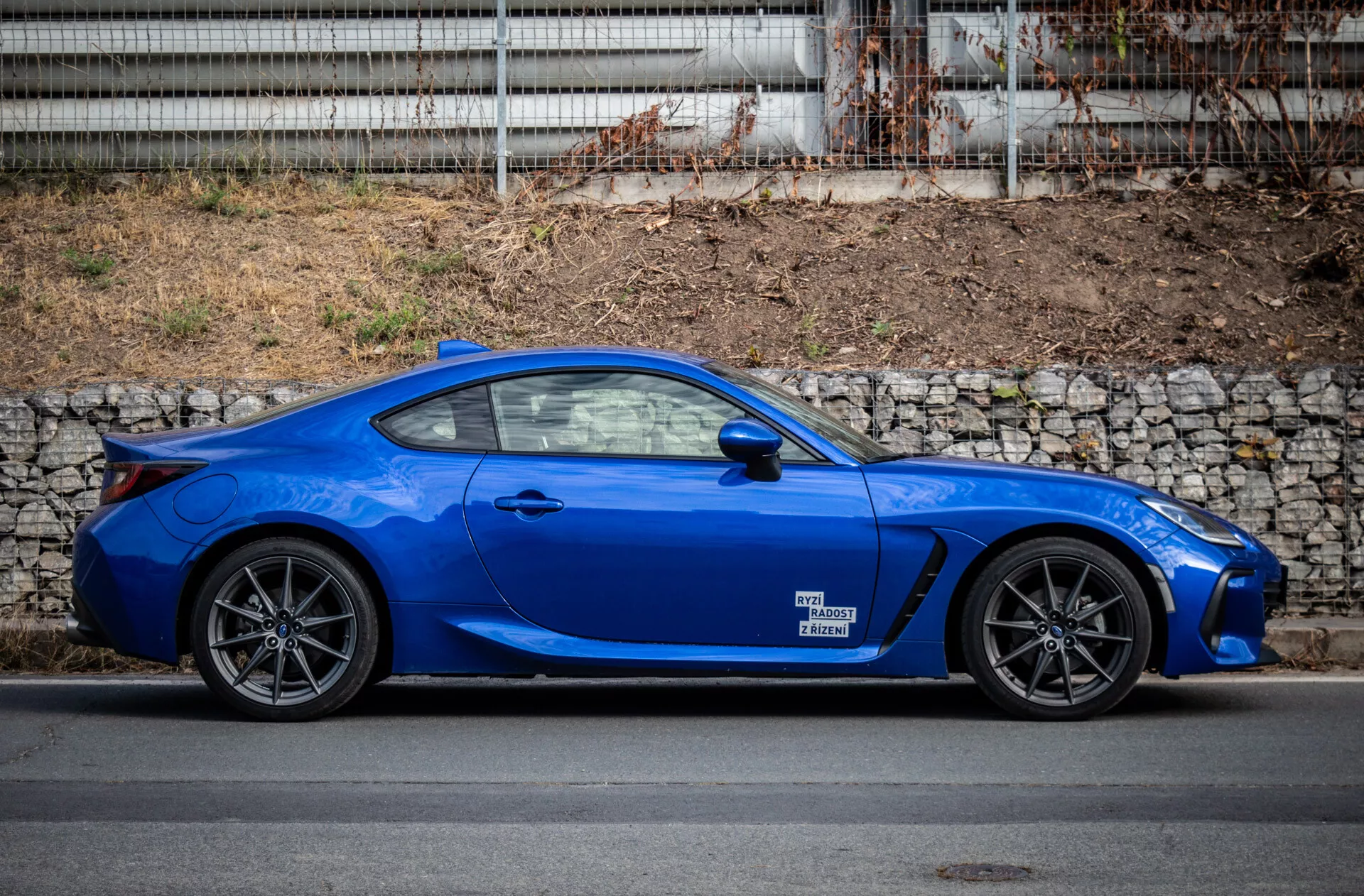 Subaru BRZ 2023, parkiran v urbanem okolju, ki prikazuje svojo elegantno obliko in živo modro barvo