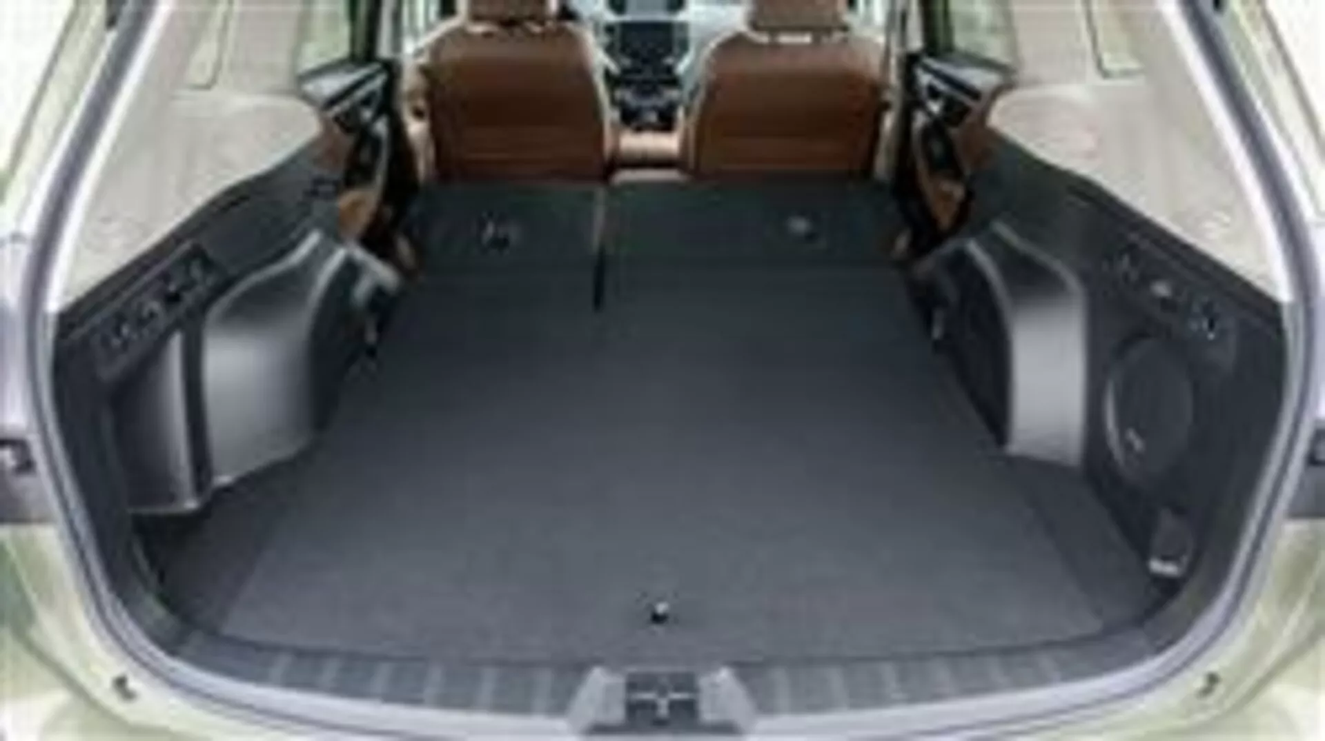 Prtljažni prostor Subaru Forester 2015 s spuščenimi zadnjimi sedeži, ki prikazuje prazen tovorni prostor in luksuzno notranjost iz rjavega usnja, pogled iz povišane perspektive