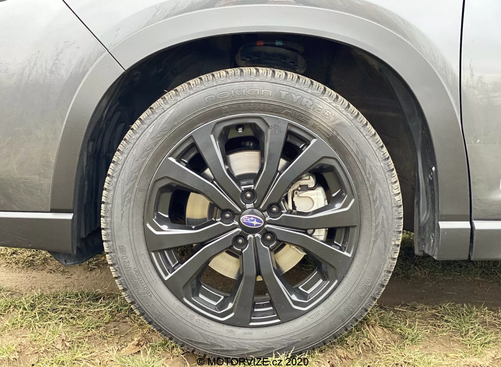 Pogled od blizu na sprednje kolo na strani sovoznika Subaru Forester 2020, ki prikazuje večkrako platišče z dvobarvno obdelavo, vidno pnevmatiko Goodyear Eagle, sredinsko kapo z logotipom Subaru, zavorno čeljust, ki nakazuje sistem zavornih diskov, in vidne sestavne dele vzmetenja, poudarjajoč podroben dizajn kolesa in zmogljivostne lastnosti vozila.