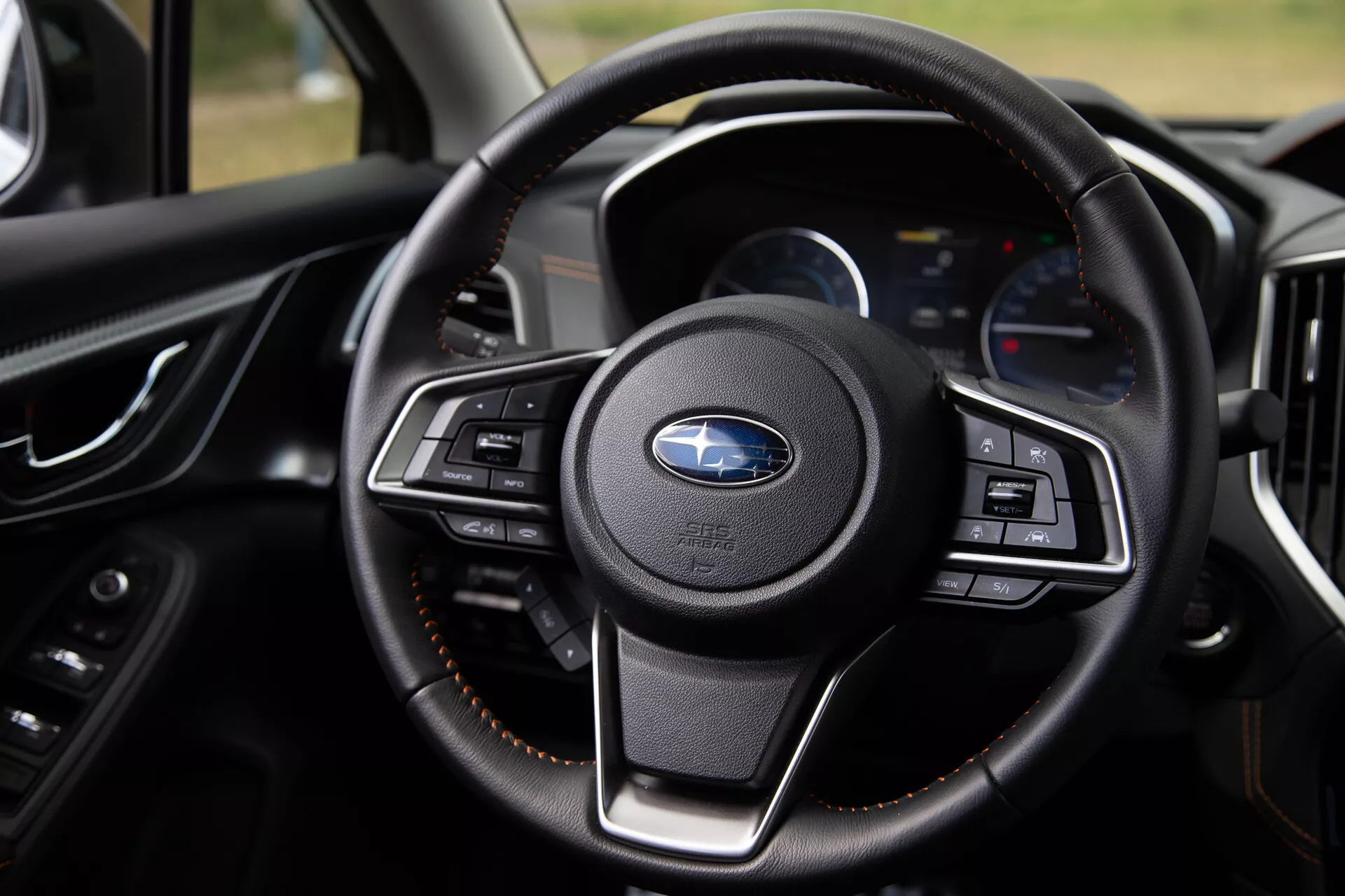 Pogled od blizu na volan Subaru XV 2021 s multifunkcijskimi gumbi, razkošnim usnjem in sodobno armaturno ploščo z digitalnimi zasloni