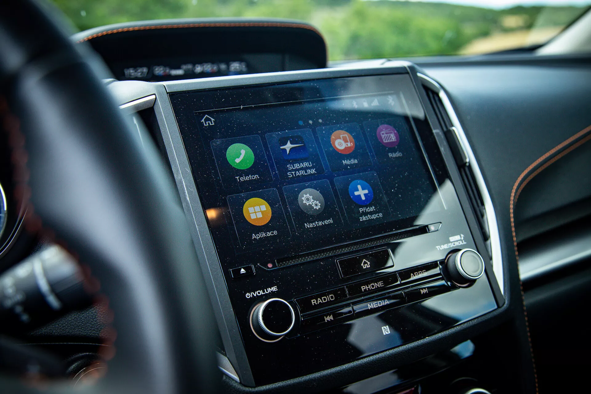 Podroben pogled na zaslon na dotik infotainment sistema Subaru XV 2021 na sredinski konzoli, iz perspektive voznika, z aplikacijami za navigacijo, povezavo s telefonom in predvajanjem glasbe