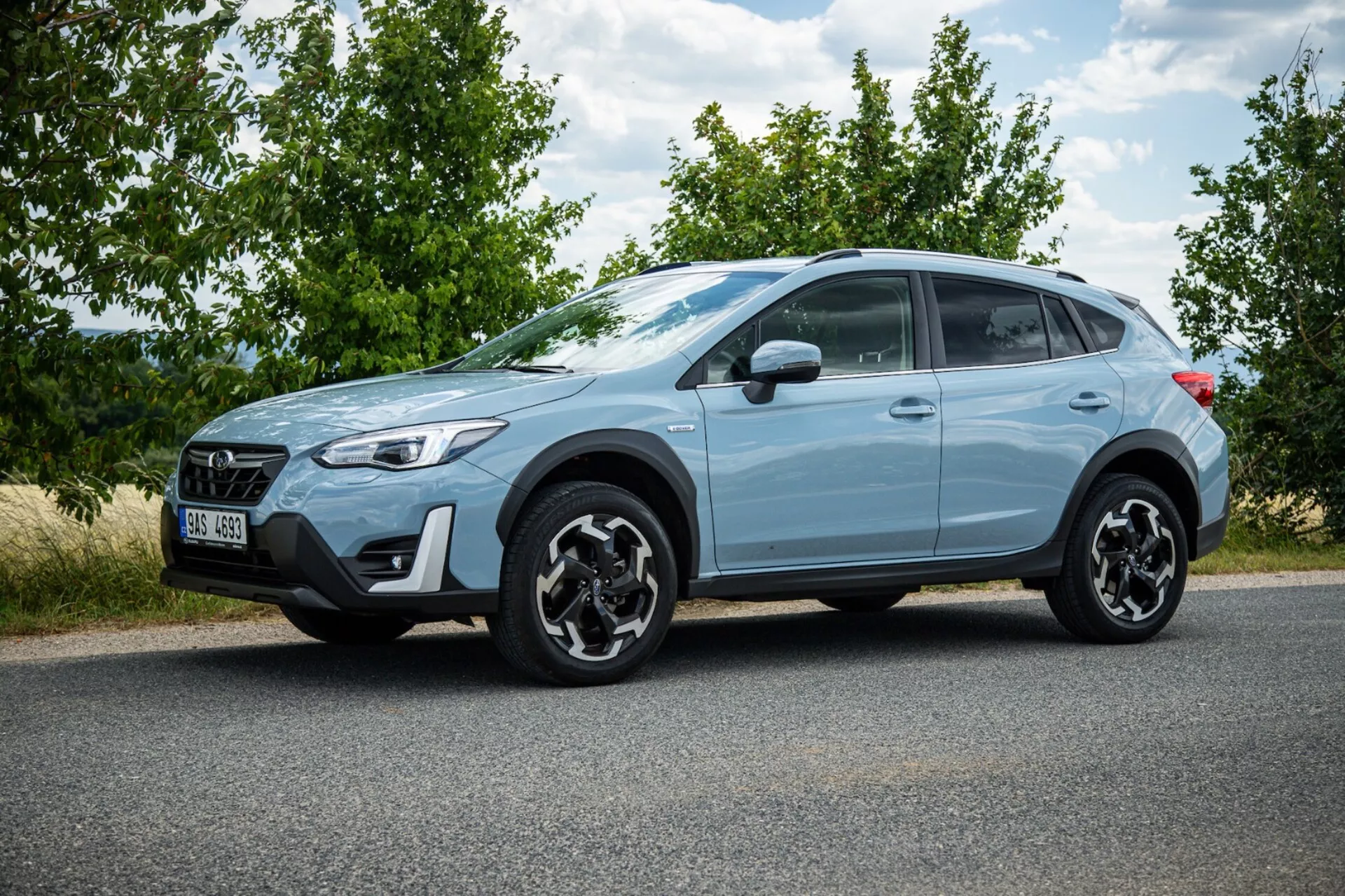 SUV križanec Subaru XV 2021 svetlo modre barve, parkiran na asfaltu, prikazuje stranski profil, izrazita črna lita platišča, LED zadnje luči, visoko oddaljenost od tal za urbano in lahko terensko uporabo ter sodobne varnostne funkcije