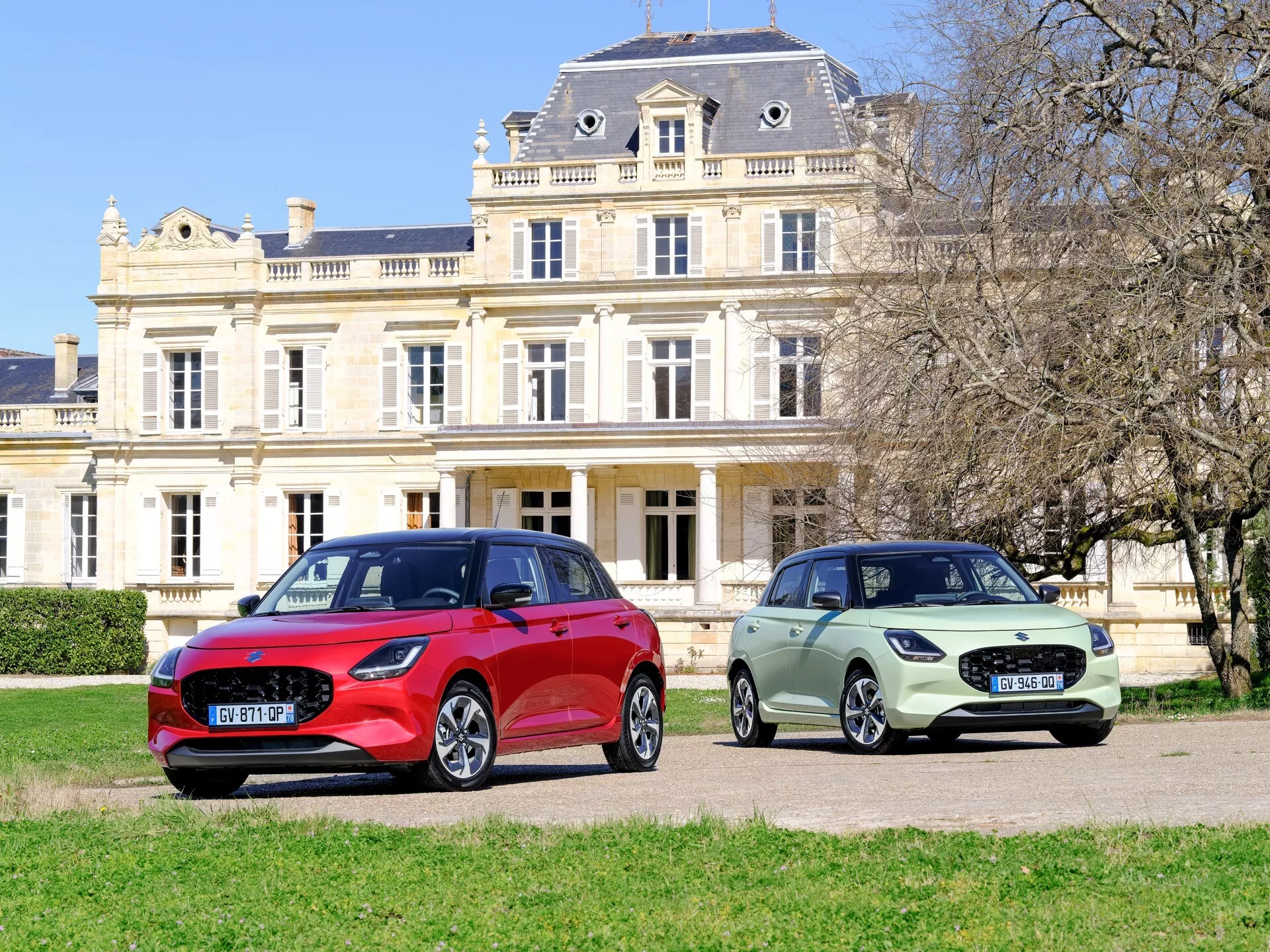 Suzuki Swift 7. generacije model leta 2024 v živahni rdeči barvi, ki prikazuje elegantno oblikovanje in napredne tehnološke značilnosti