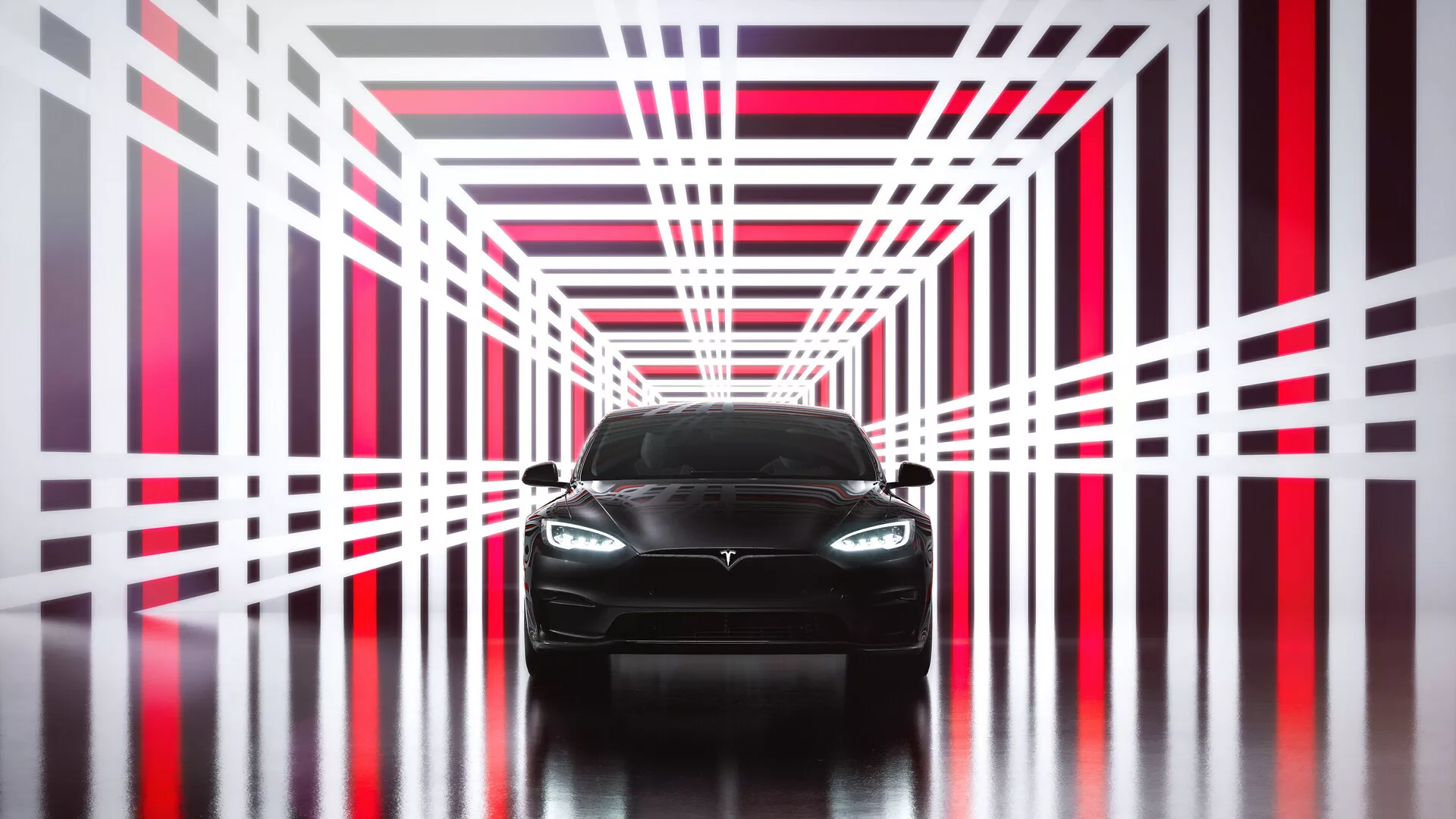 Sprednji pogled Tesle Model S 2016, prva generacija prenove. Sliko poudarja sodoben in eleganten dizajn z agresivno sprednjo fasado z jasno vidnim emblemom na rešetku, modernimi LED ali HID žarometi in gladkimi konturami pokrova. Spodnji odbijač nakazuje športni značaj z vstopnimi odprtinami za zrak, medtem ko avto stoji na odsevni površini v futuristični tunelski strukturi s svetlo rdečimi in belimi neonskimi lučmi. Neposreden simetričen pogled poudarja dizajn in simetrijo, zaradi česar je popoln za predstavitev v avtomobilskih marketinških materialih.