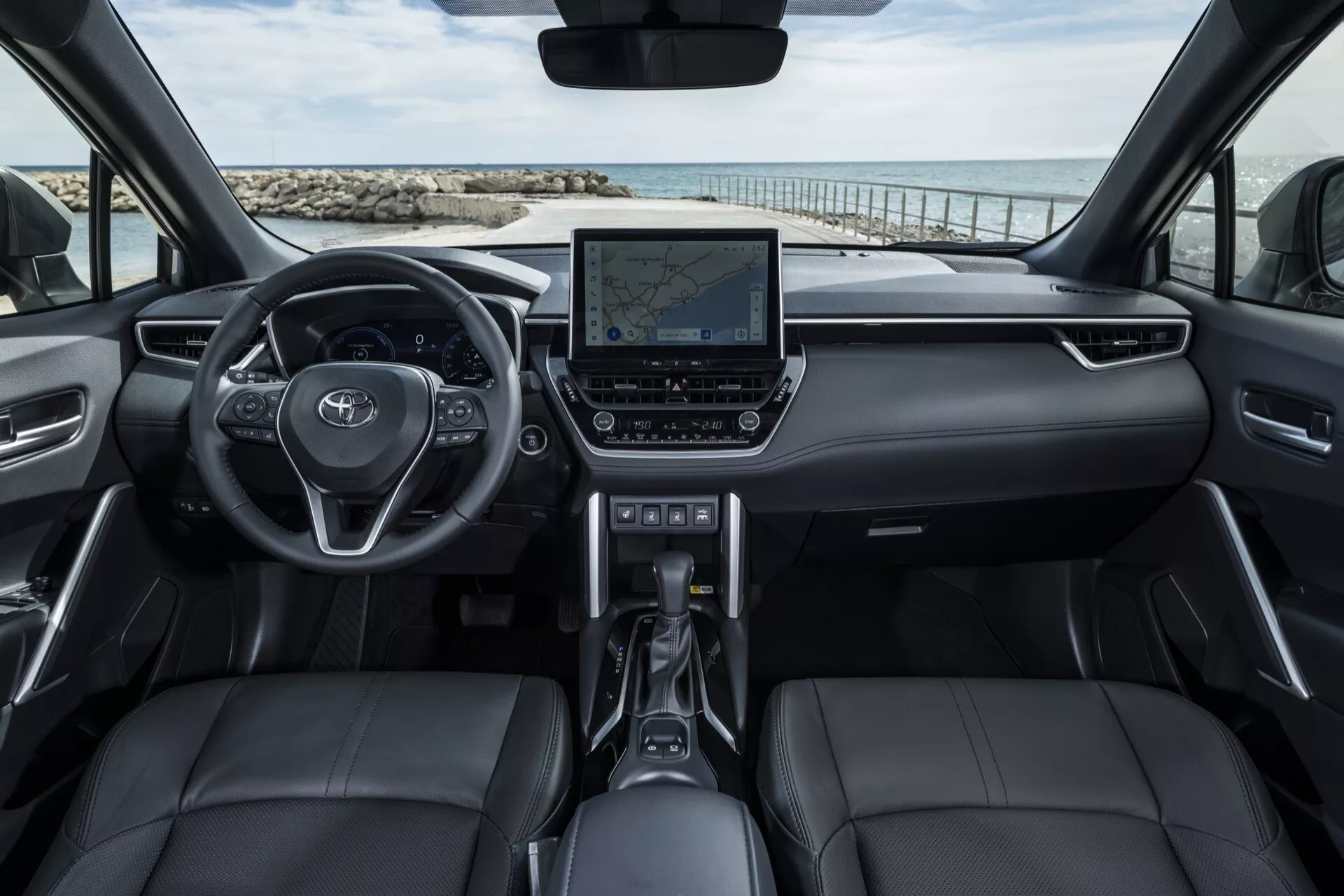 Notranjost Toyota Corolla Cross 1. generacije letnik 2022 z multifunkcijskim volanom, digitalnim zaslonom armaturne plošče, sedeži iz črnega usnja in naprednim informacijsko-zabavnim sistemom