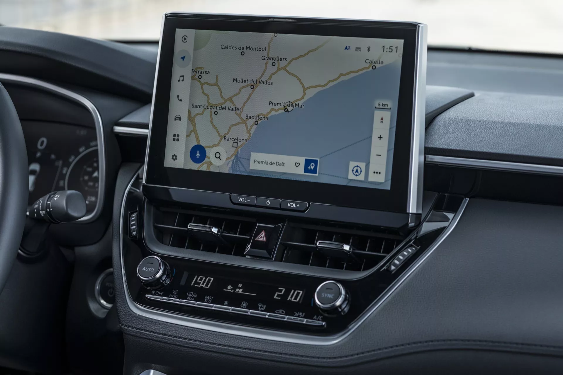 Notranjost Toyota Corolla Cross 2022 s poudarkom na informacijsko-zabavnem sistemu in sredinski konzoli z vidno GPS navigacijo in klimatsko kontrolo
