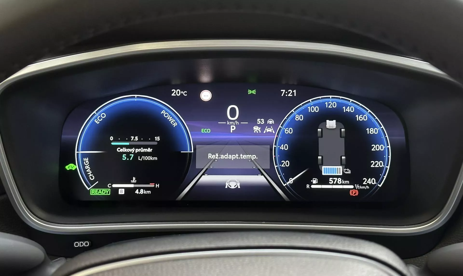 Podroben pogled na digitalno armaturno ploščo Toyota Corolla Cross 2022, ki prikazuje hibridni hitrostomer, merilec porabe energije in napredne funkcije vozila iz perspektive voznika
