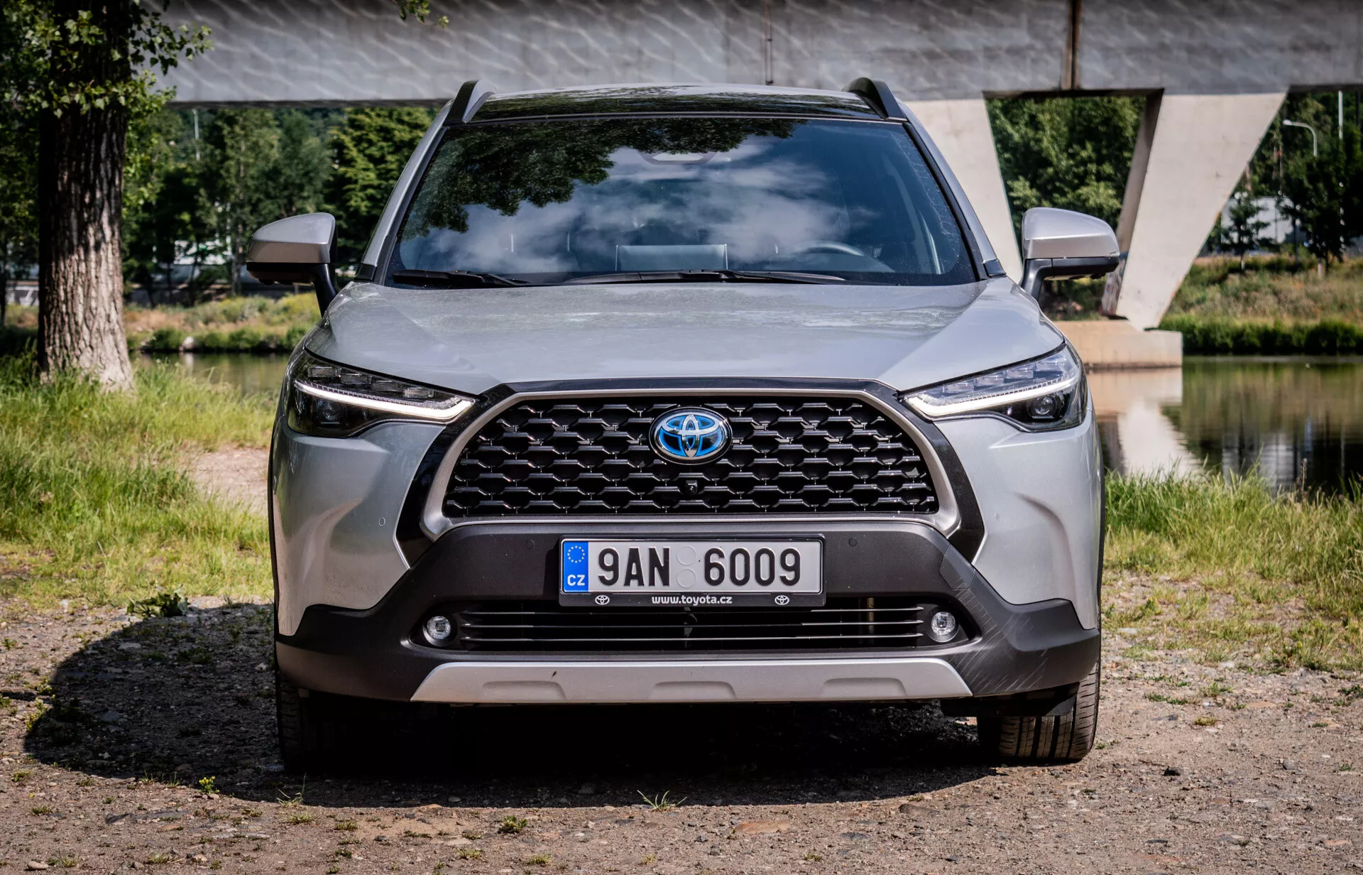 Sprednji pogled na Toyota Corolla Cross 2022, ki prikazuje rešetko, žaromete in odbijač, poudarja napredno oblikovanje in tehnologijo