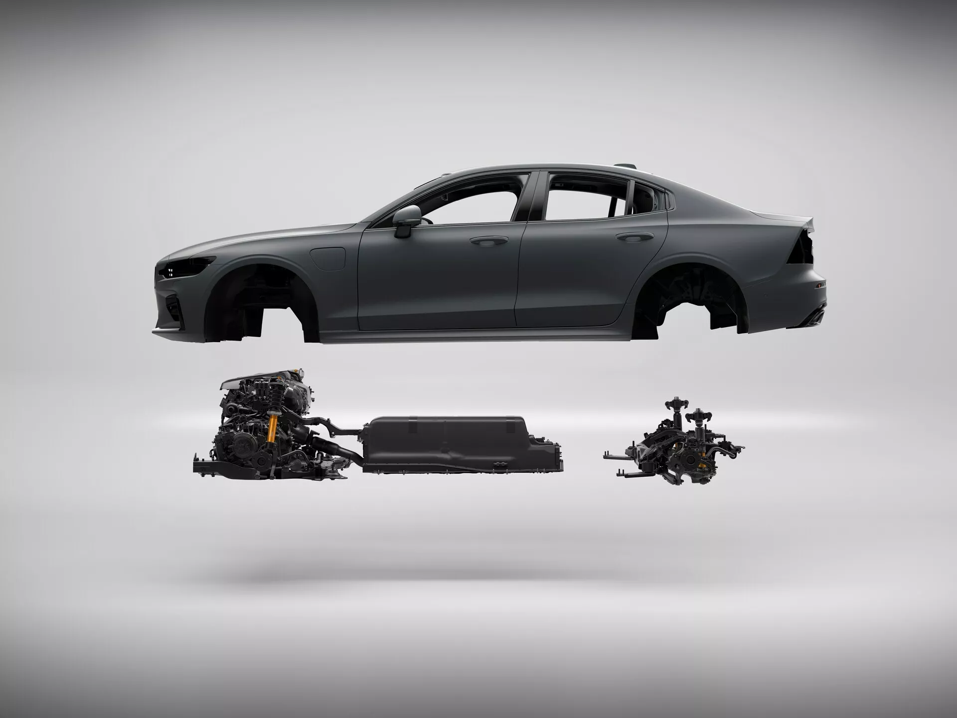 Profilni pogled na sodoben avto Volvo S60-V60 2018 (3. generacija) brez koles na nevtralnem sivem ozadju. Avto se zdi, da lebdi v zraku, razkrivajoč svoje notranje komponente: sistem pogona sprednjih koles, baterijski paket in sistem pogona zadnjih koles. Ta slika poudarja tehnologijo električnih/hibridnih vozil z natančnim poravnanjem komponent pogonskega sklopa.