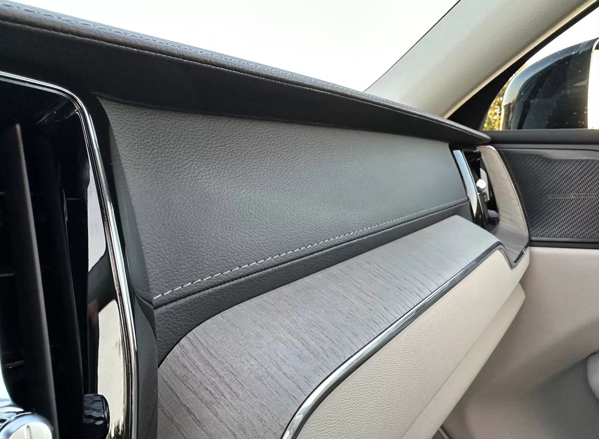 Podroben pogled na notranjo ploščo vrat Volvo XC60 2021 Recharge Plug-In Hybrid, ki poudarja luksuzne materiale in oblikovalske elemente iz perspektive potnika.