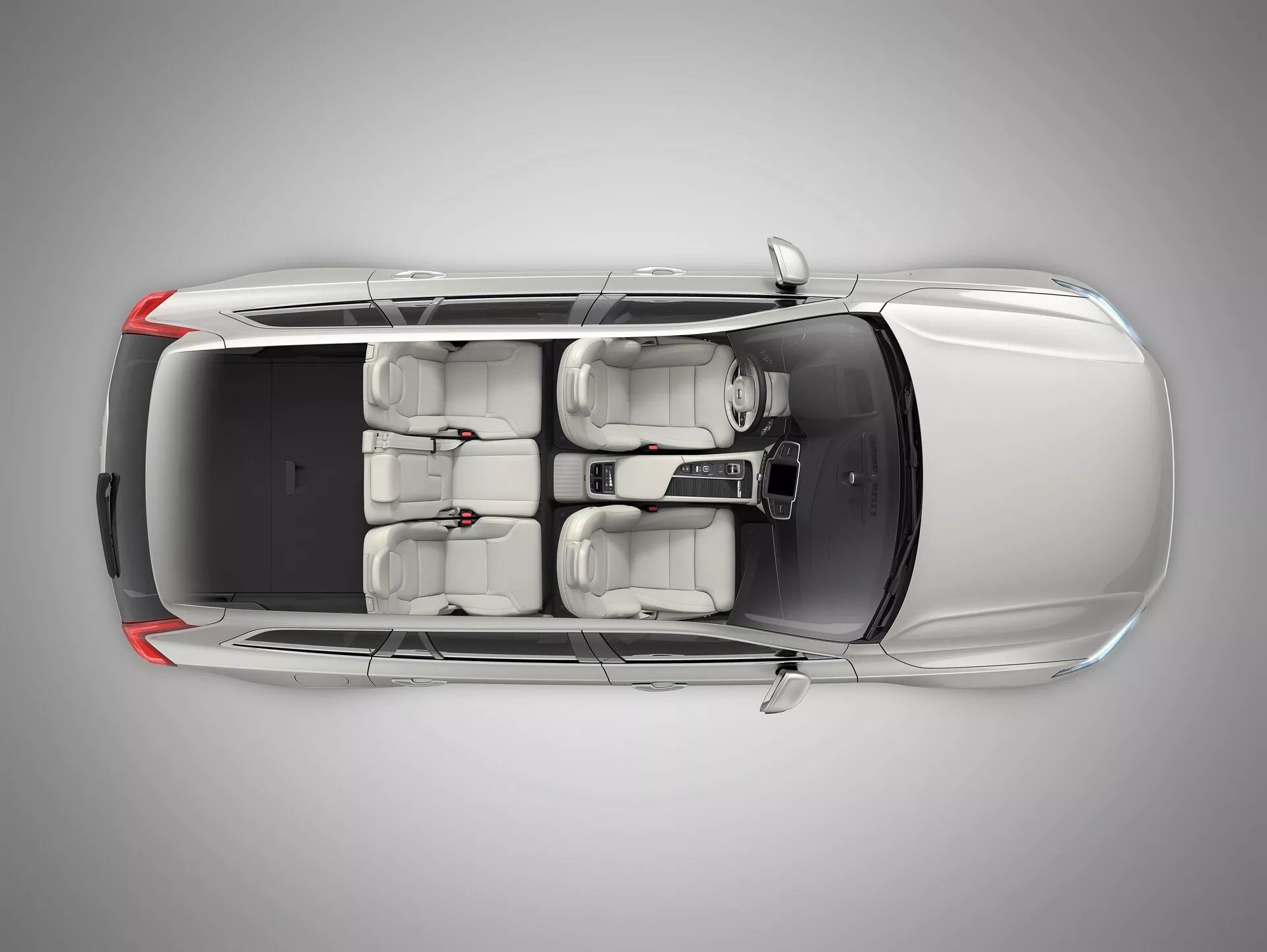 Pogled iz ptičje perspektive na Volvo XC90 2015 (2. generacija), ki prikazuje luksuzno limuzino od zgoraj. Kot zagotavlja jasen pogled na streho, pokrov motorja, prtljažnik in površine vrat. Lastnosti vključujejo dvopanelno strešno okno nad sprednjimi sedeži, svetlo notranjost s petimi sedeži, lita platišča in vidna stranska ogledala. Zadnje okno je strmo nagnjeno, nobeni specifični identifikatorji znamke pa niso vidni.