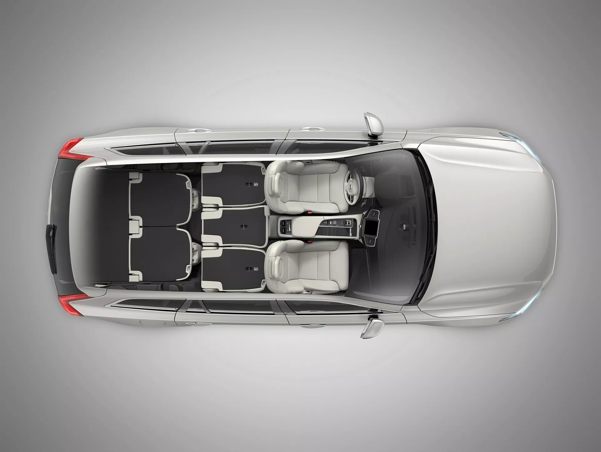 Ptičji pogled na Volvo XC90 druge generacije iz leta 2015, ki prikazuje črno streho in kovinsko srebrno ali sivo karoserijo s strešnim oknom, zaprtimi vrati in okni. Vidna so vsa kolesa in oblikovanje platišč, pa tudi stranska ogledala, kar poudarja varnost in zunanje funkcije. Zožena linija strehe proti zadku nakazuje, da bi lahko šlo za štirivratni limuzinski model ali kupé.