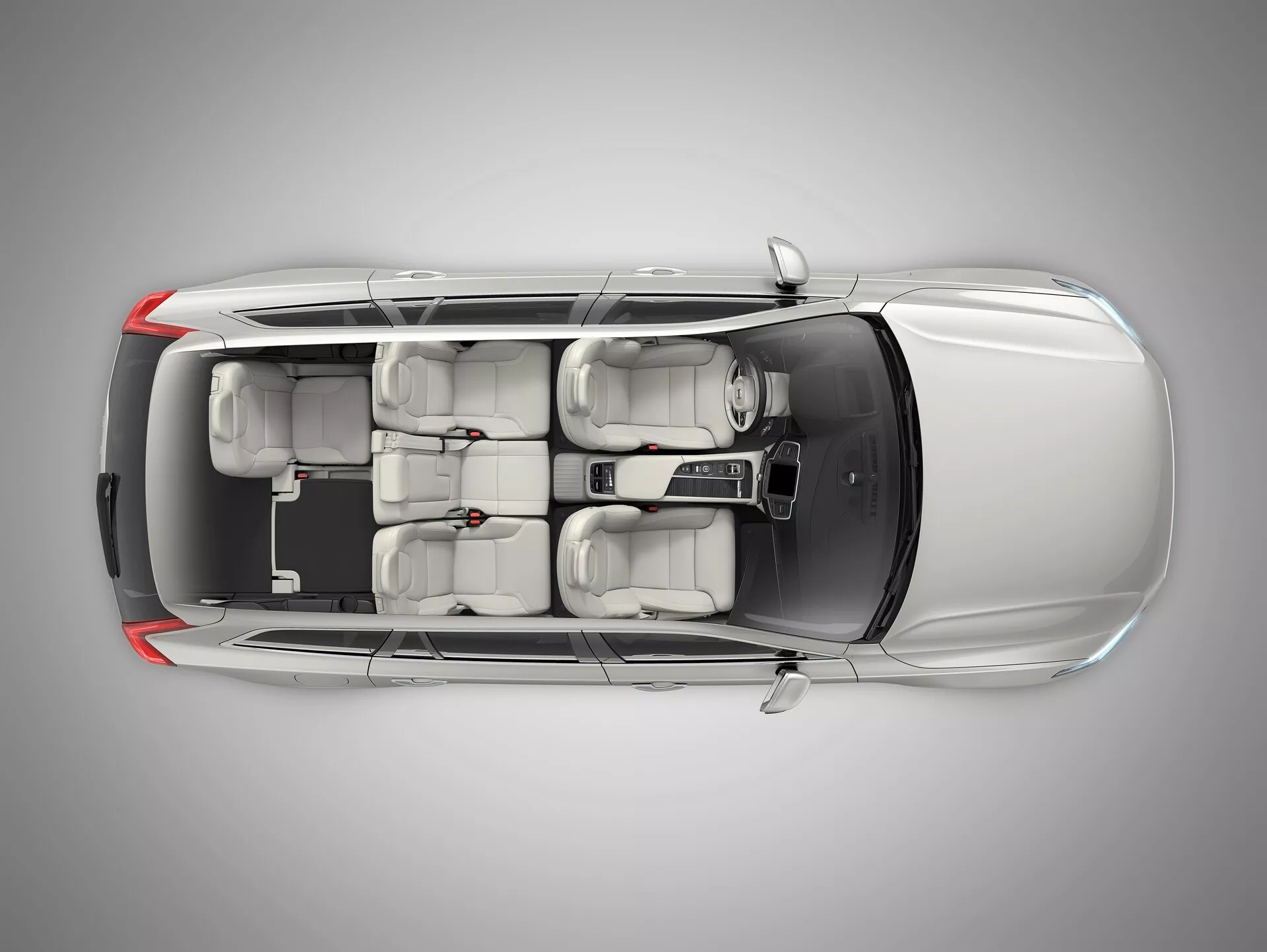 Zračni pogled od zgoraj na dobro vzdrževan srebrni avto Volvo XC90 druge generacije iz leta 2015. Slika zajema celotno dolžino in širino avtomobila, pri čemer prikazuje celotno streho, karoserijo in okolico. Vsa okna in vrata so zaprta, z ročaji vrat integriranimi v dizajn ter z zloženimi stranskimi ogledali. Streha nima strešnega okna, barva je enakomerno svetleča. Notranjost je vidna skozi prozorno streho, poudarjajoč bež ali svetlo sivo oblazinjenje, dve vrsti sedežev z naslonjali za glavo ter standardne pnevmatike. Oblika ohišij zadnjih in sprednjih luči je vidna, vendar ni podrobna.