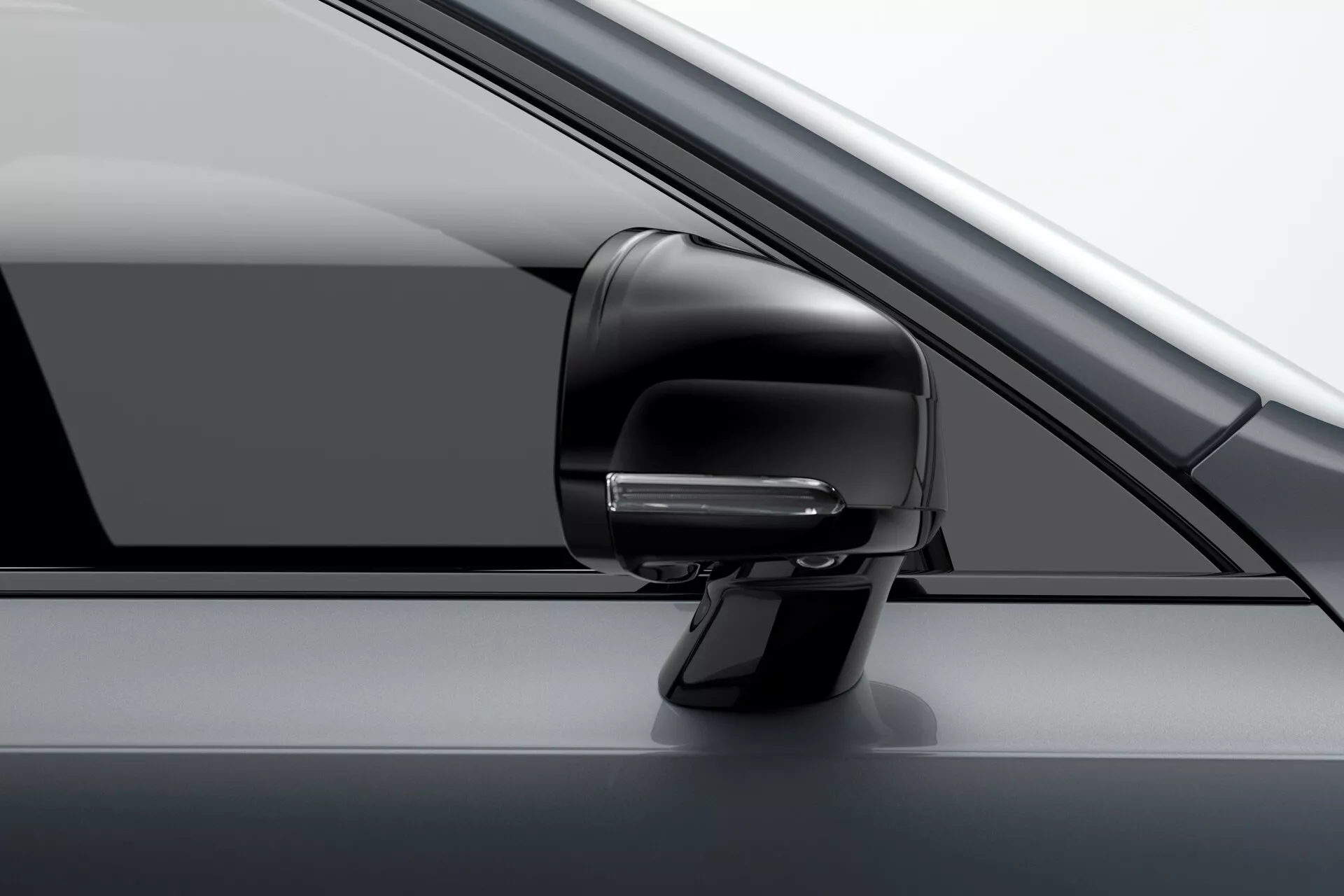 Podroben pogled na sklop stranskega ogledala na voznikovi strani pri vozilu Volvo XC90 2015 (2. generacija). Slika poudarja sodoben aerodinamičen dizajn z vgrajenim smernikom, ki je verjetno del naprednega sistema za asistenco pri vožnji, in ohišje v barvi vozila. Delno je viden A-stebriček, stransko okno in vratna plošča. Fotografija je posneta iz rahlo sprednjega zornega kota, kar prikazuje luksuzen, enobarven videz vozila.