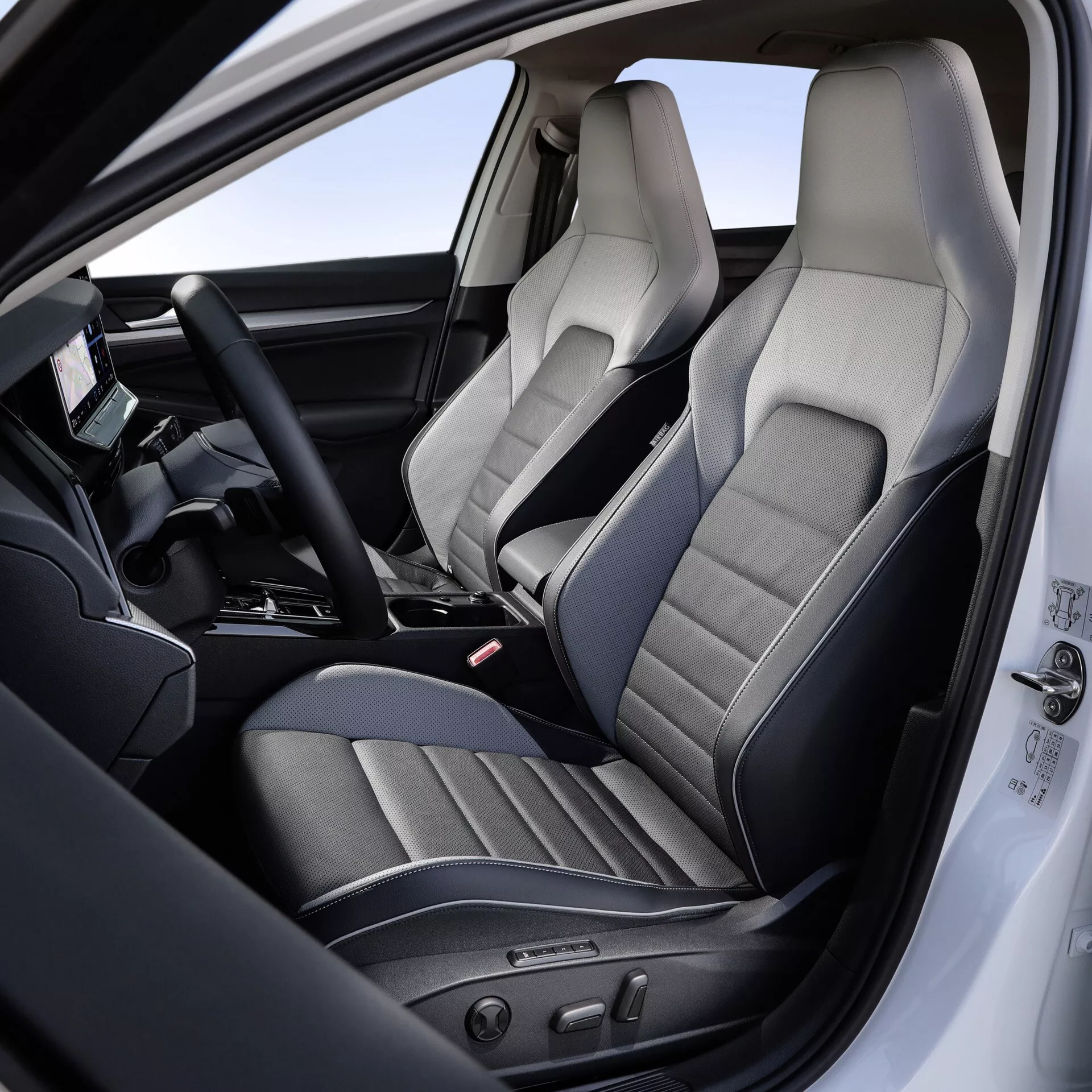 Pogled na notranjost VW Golfa 2024 (VIII-facelift) osredotočen na voznikov prostor in sedež sovoznika, poudarja sedeže iz premium usnja z detajlnim šivanjem, elektronsko nastavitev sedeža, multifunkcijski volan z digitalnim zaslonom in napredne funkcije sredinske konzole.