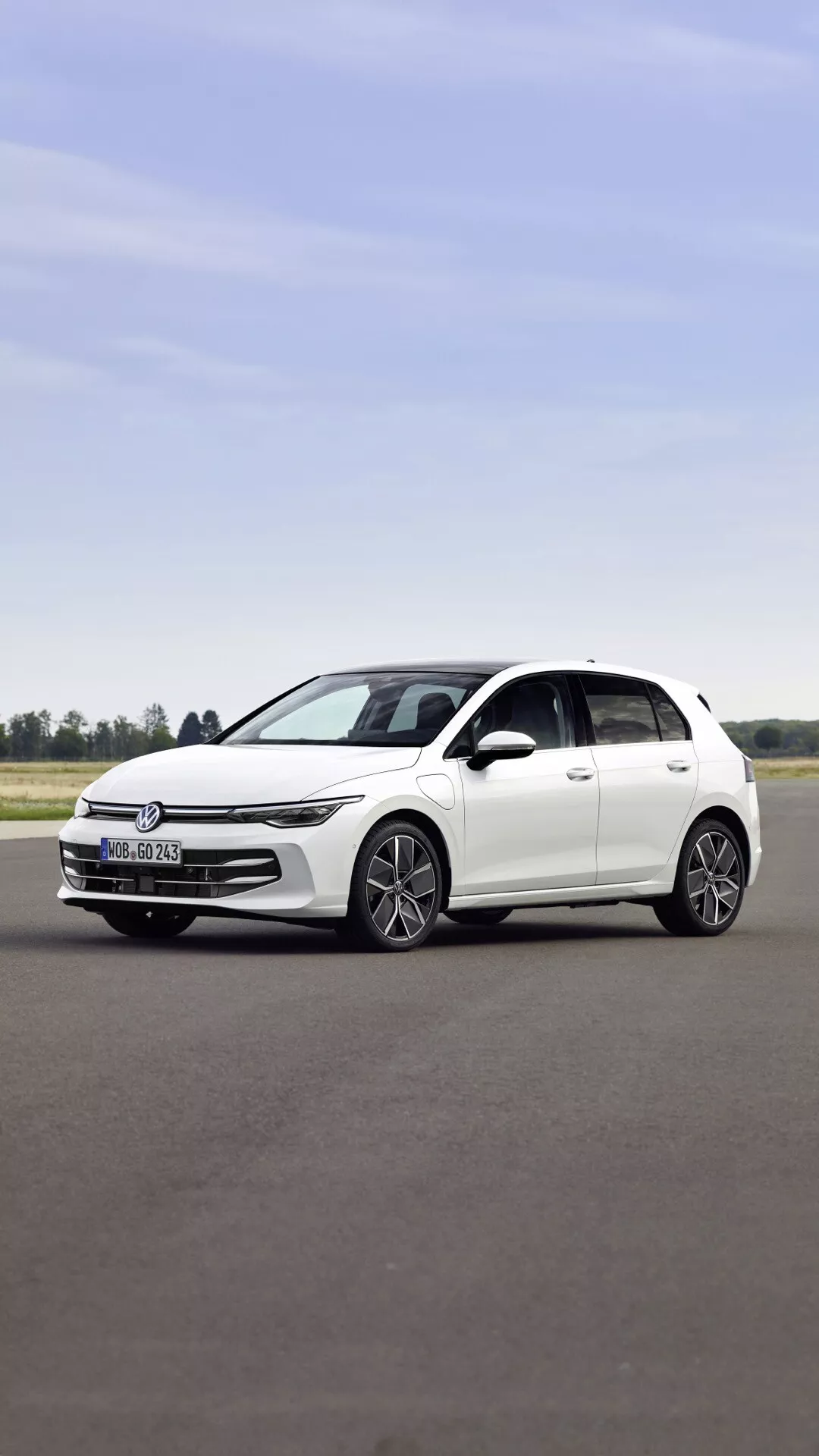 Model VW Golf VIII 2024 po prenovi, bela petvratna kombilimuzina, pogled s strani na asfaltu prikazuje silhueto, elegantno zasnovo žarometov, sodobna platišča iz zlitine in ogledala v barvi karoserije brez vidne strešne okenske