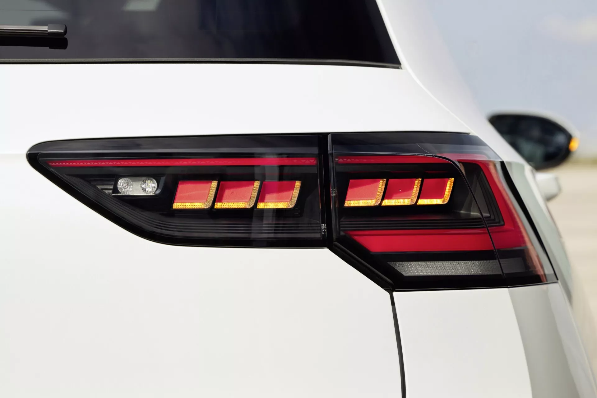 Podroben pogled na zadnji kot VW Golf 2024 (VIII-Facelift) z LED zadnjimi lučmi, ki poudarja moderno in luksuzno estetiko vozila