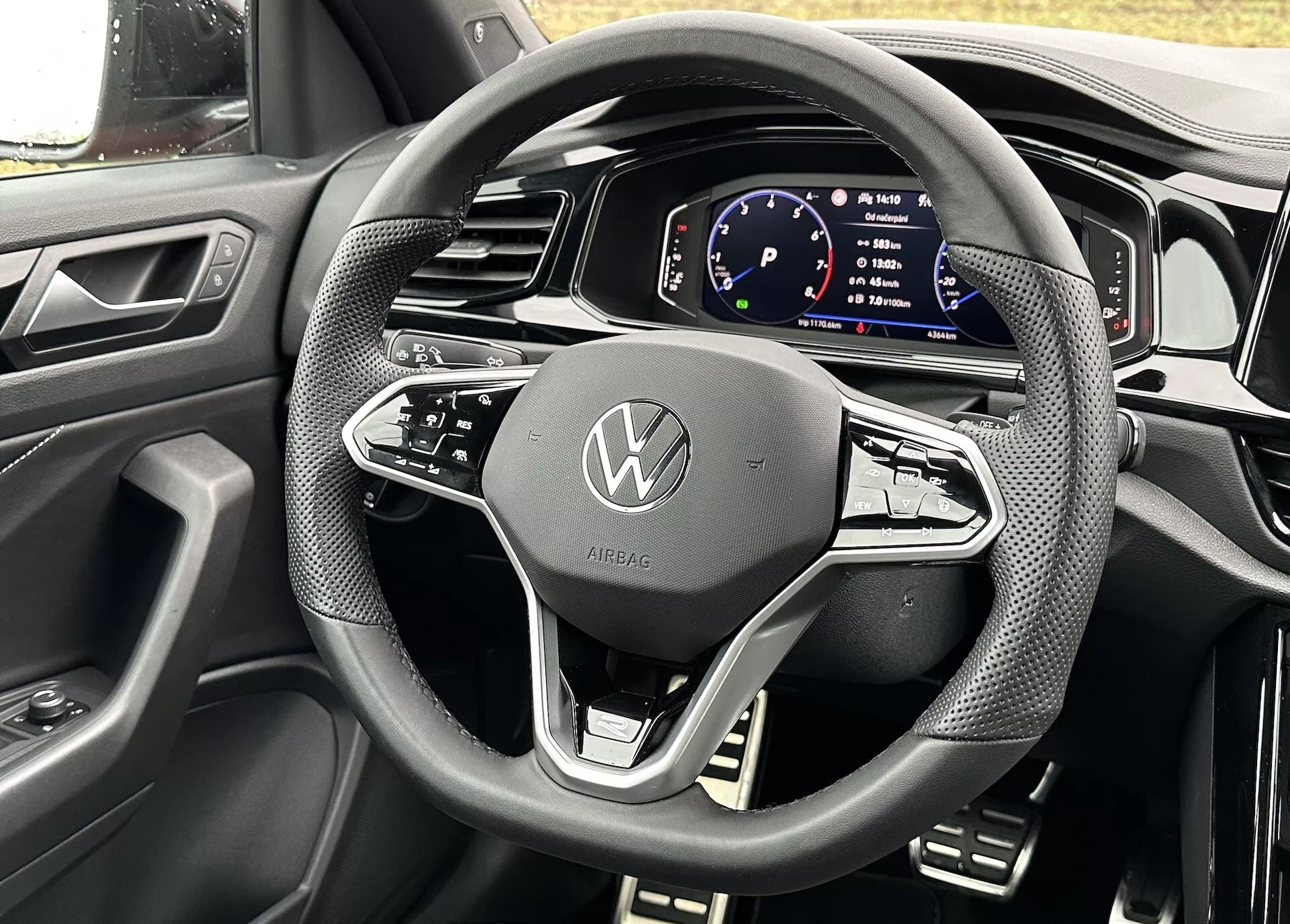 Podroben pogled iz perspektive voznika na volan in digitalni instrumentni zaslon kabrioleta Volkswagen T-Roc 2022, ki prikazuje sodobno oblikovanje in tehnološke značilnosti